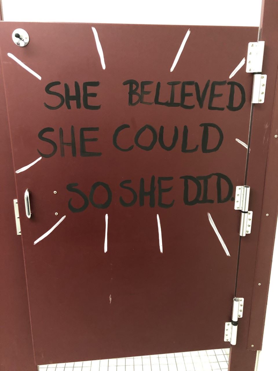 "She believed she could so she did" painted on door of  bathroom stall